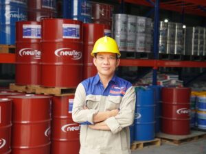 Person in safety gear stands confidently among colorful barrels.