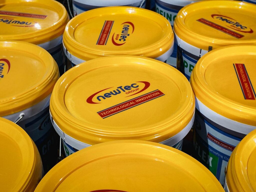 Yellow paint buckets with labels stacked closely together.